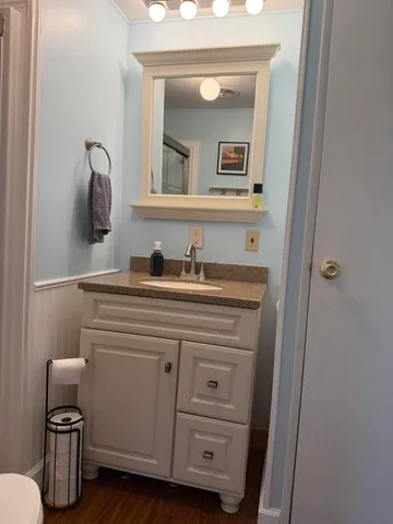 a bathroom with a toilet a sink and mirror