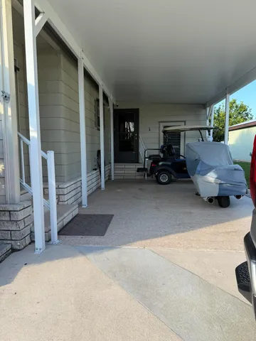 a view of a livingroom with furniture and a cars parked in garage