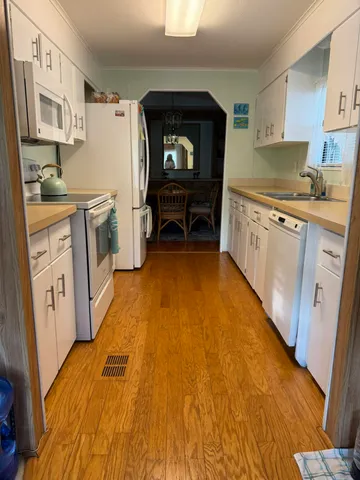 a kitchen with a sink cabinets and wooden floor