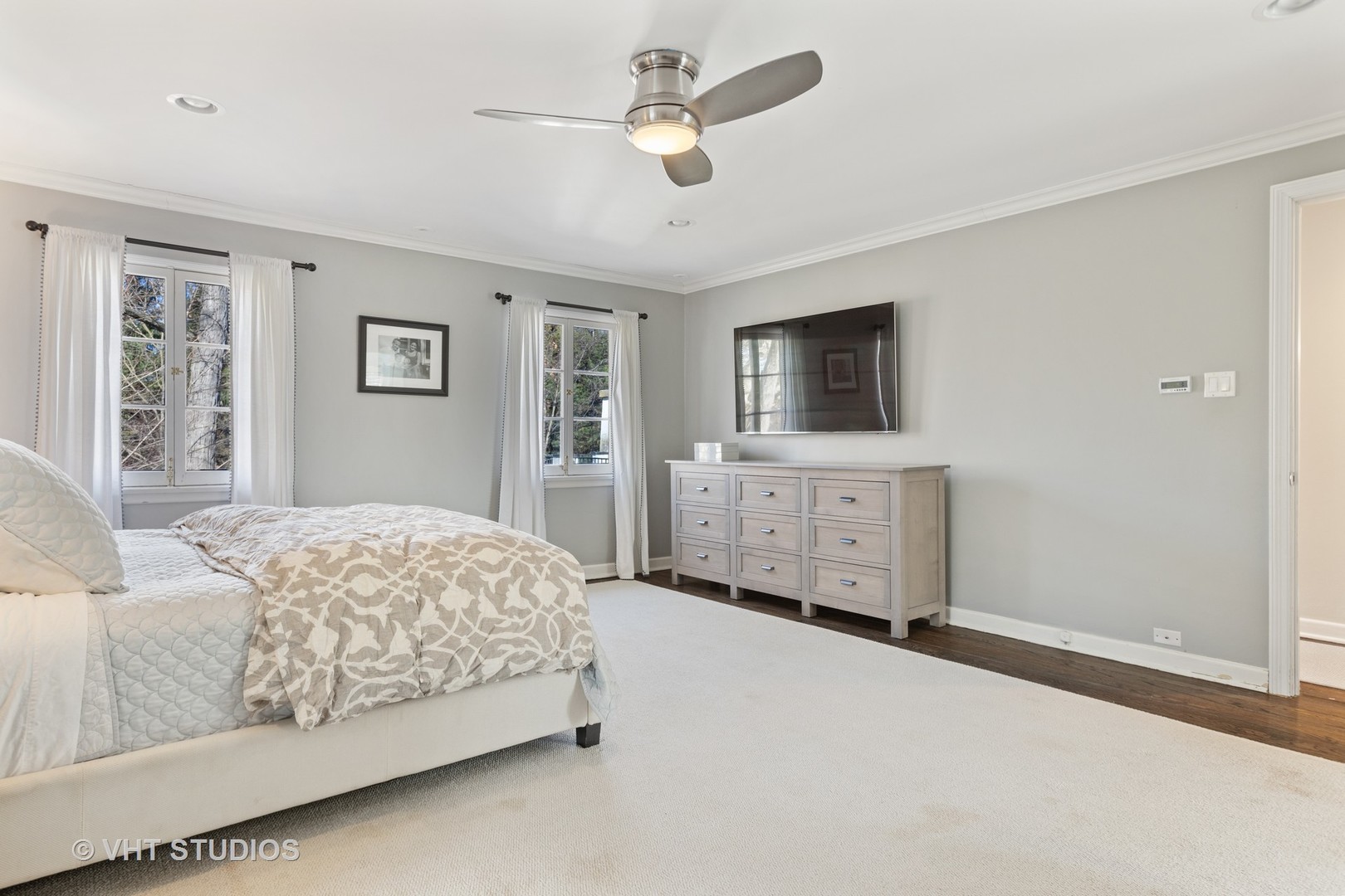 128 Church Road Winnetka, IL 60093 - Photo 24 of 46 a bedroom with a large bed a chandelier and a flat tv screen