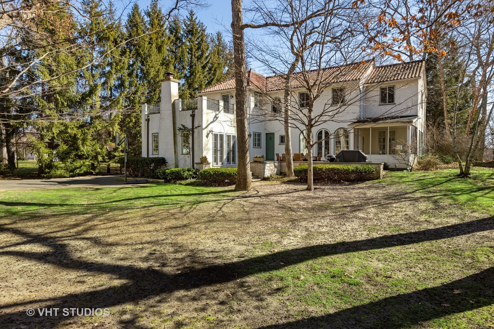 128 Church Road Winnetka, IL 60093 - Photo 40 of 46 a view of a white house next to a yard with big trees