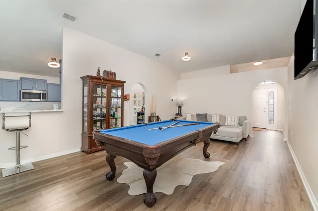 a living room with a table chairs and a flat screen tv