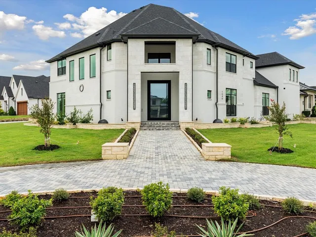 a front view of a house with a yard and potted plants