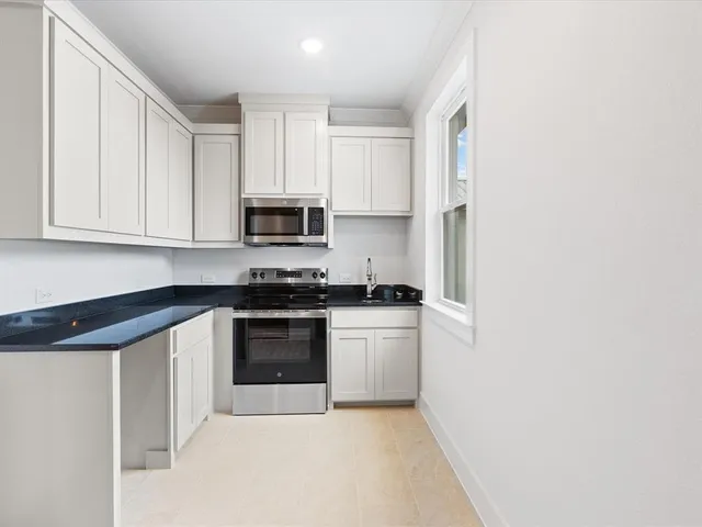 a kitchen with stainless steel appliances granite countertop a stove a sink and a microwave