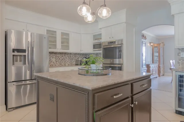a kitchen with stainless steel appliances granite countertop a refrigerator and a sink