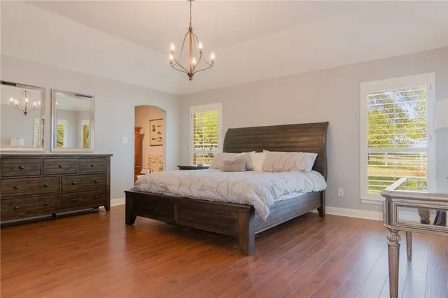 a spacious bedroom with a bed and a dresser next to a window