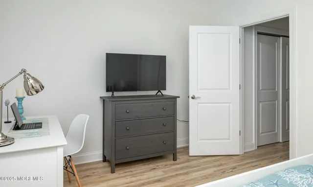 a room with a flat screen tv and dresser
