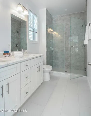 a bathroom with a shower sink vanity and toilet