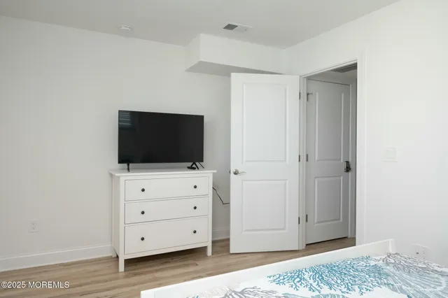 a room with a television and a dresser