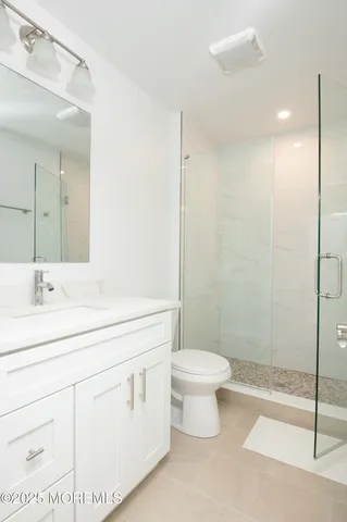 a bathroom with a double vanity sink toilet and shower