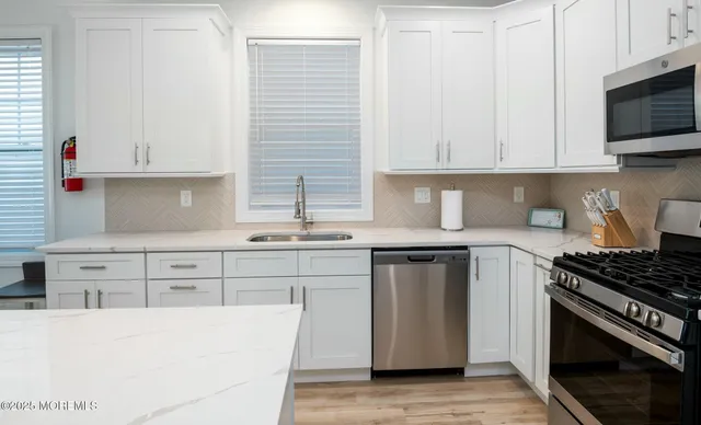 a kitchen with stainless steel appliances granite countertop a stove a sink and a microwave