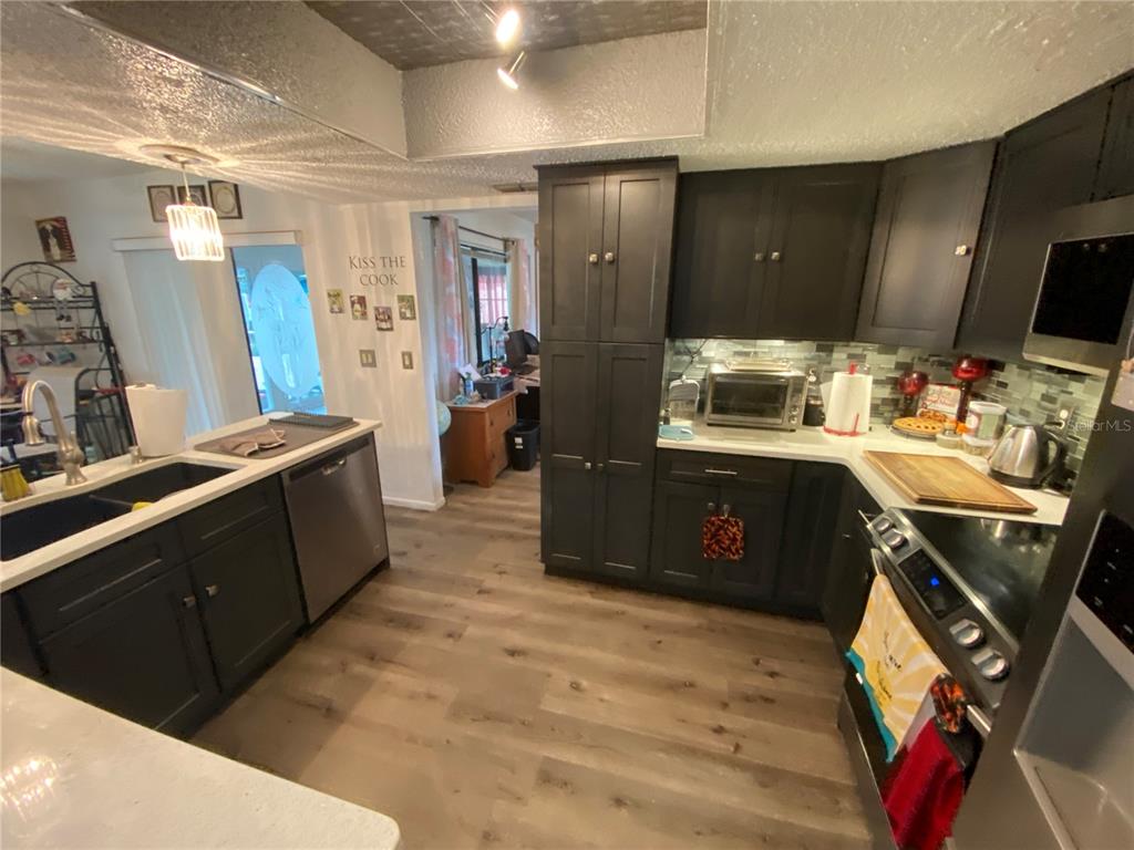 4100 Montano Avenue Spring Hill, FL 34609 - Photo 12 of 59 a kitchen with stainless steel appliances granite countertop a sink stove and refrigerator