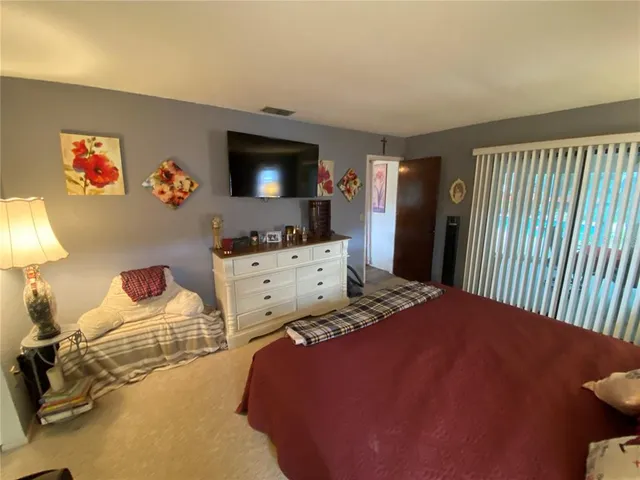 a bedroom with a bed and a tv on the dresser