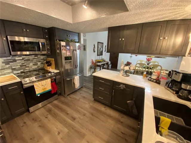 a kitchen with a refrigerator sink and wooden floor