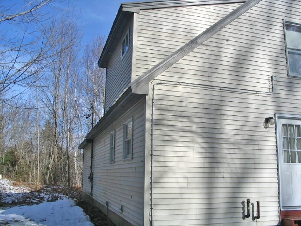 327 Kennebec Road Hampden, ME 04444 - Photo 6 of 34 Exterior Back. Wooded area behind...
