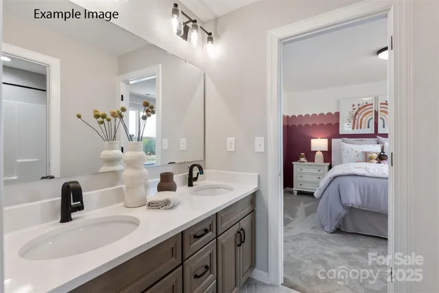 a en suite bathroom with a double vanity sink and a mirror