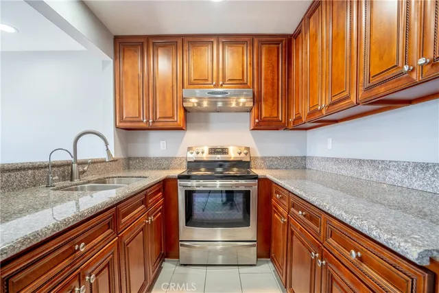 a kitchen with granite countertop a sink stainless steel appliances and cabinets