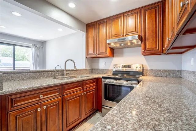 a kitchen with stainless steel appliances granite countertop a sink stove and cabinets