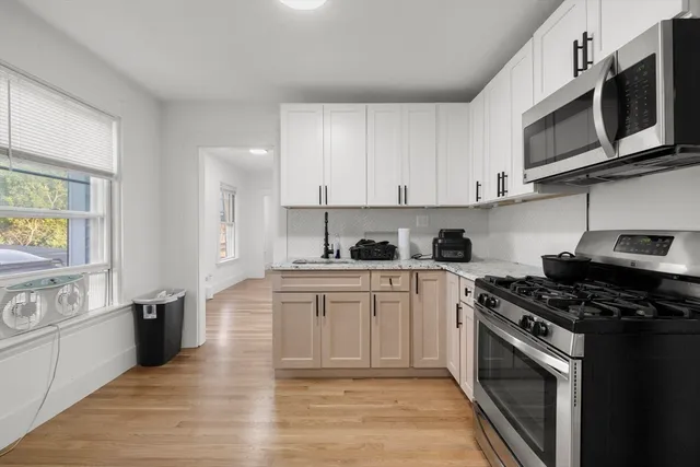 a kitchen with stainless steel appliances granite countertop a stove a sink and a microwave