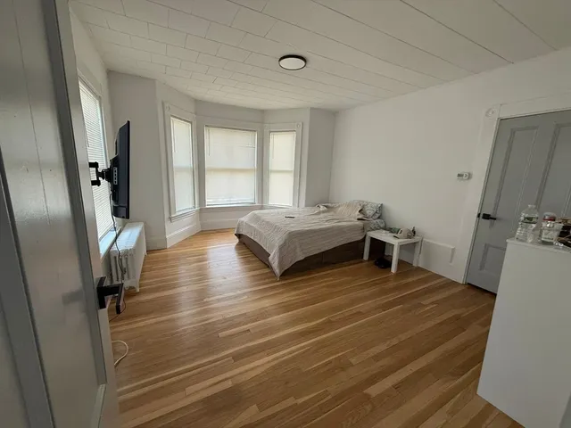 a spacious bedroom with a bed and a large window
