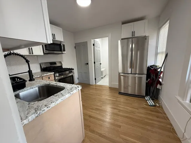 a kitchen with stainless steel appliances granite countertop a refrigerator and a sink
