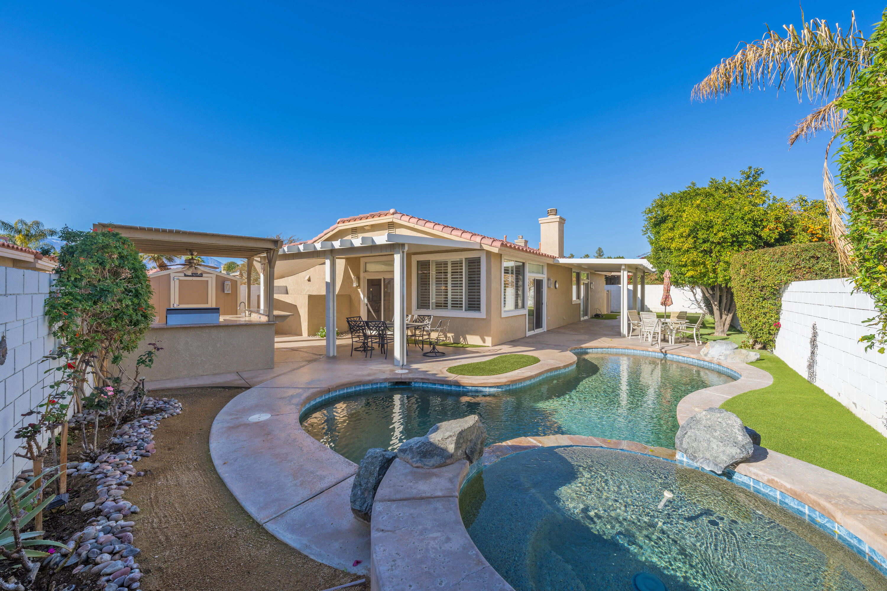 a front view of a house with swimming pool having outdoor seating