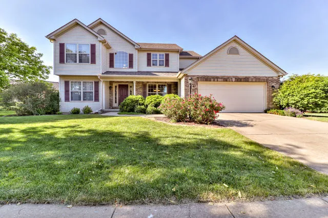 a front view of a house with yard and green space
