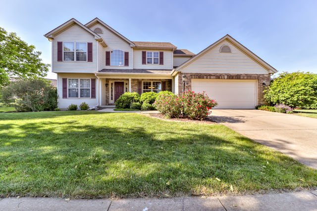 a front view of a house with yard and green space