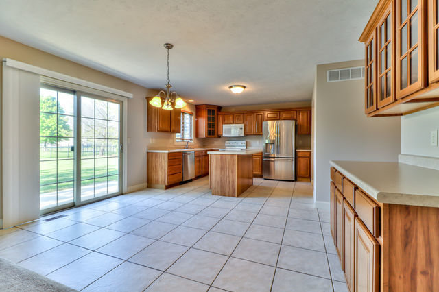 2515 St Andrews Road Urbana, IL 61802 - Photo 12 of 50 a kitchen with stainless steel appliances granite countertop a stove top oven a sink dishwasher and a refrigerator with cabinets