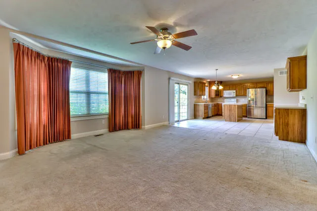 a view of empty room with a ceiling fan and window