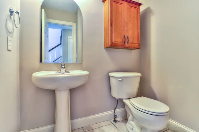 a bathroom with a toilet sink and mirror