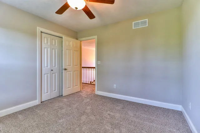 an empty room with chandelier fan