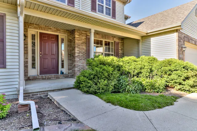 a view of a brick house with a yard and plants