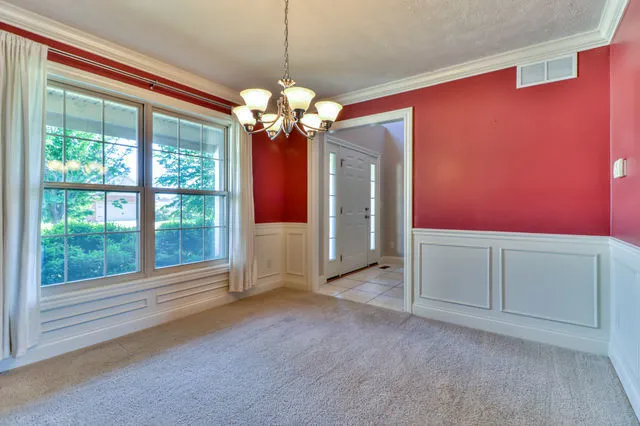 a view of a livingroom with a chandelier fan and windows