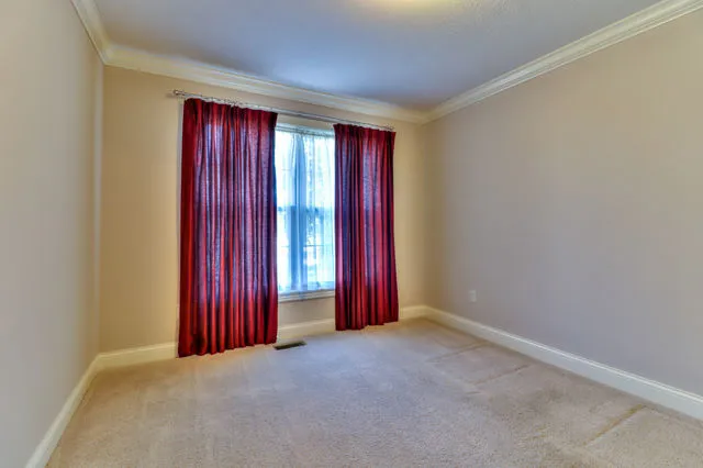 an empty room with red walls and a window