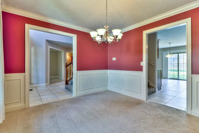 a view of a livingroom with a chandelier fan and windows