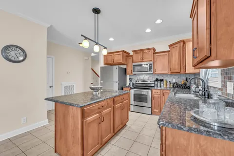 a kitchen with stainless steel appliances granite countertop a sink a stove and a refrigerator