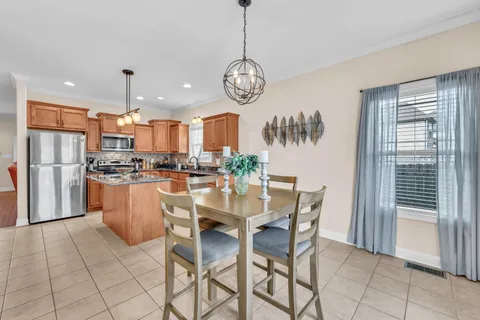 a view of kitchen with refrigerator a dining table and chairs