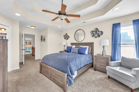 a bedroom with a large bed and a chandelier