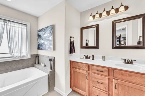 a bathroom with a tub a sink and large window