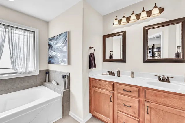 a bathroom with a tub a sink and large window