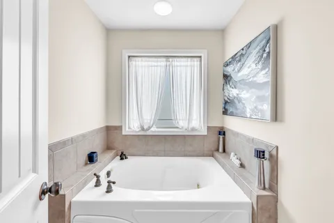 a bathroom with a bathtub and a window