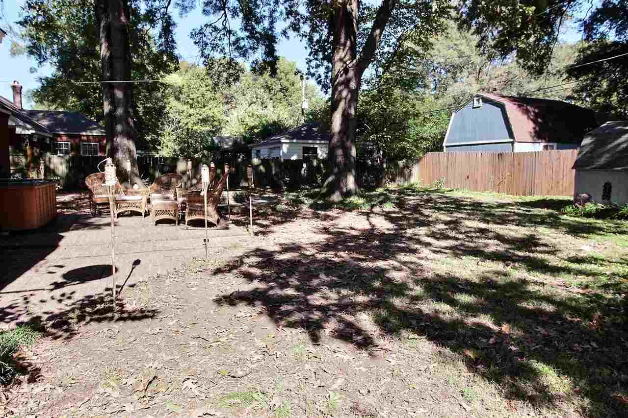 1654 Colonial Road Memphis, TN 38117 - Photo 11 of 14 a backyard of a house with table and chairs under an umbrella