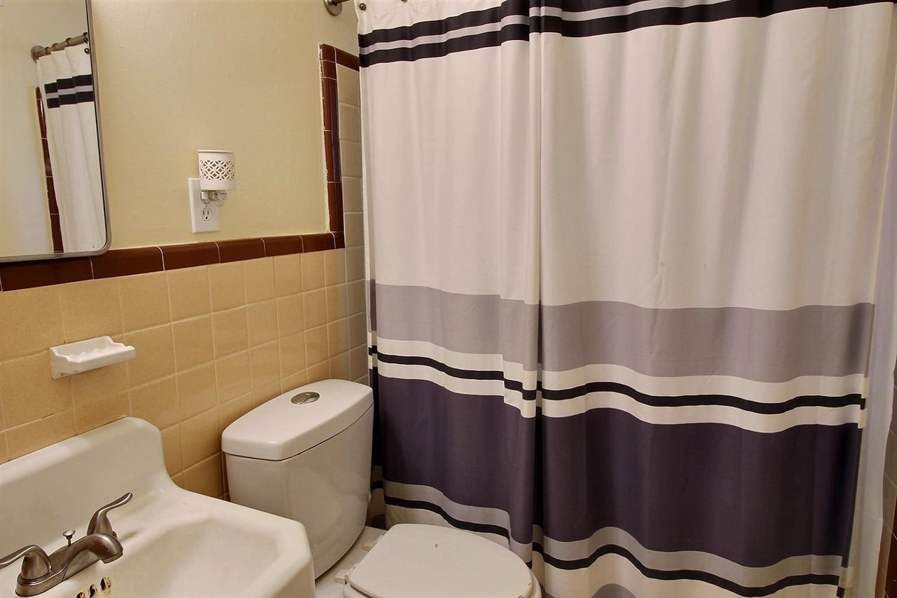 1654 Colonial Road Memphis, TN 38117 - Photo 8 of 14 a bathroom with a sink a toilet a mirror and shower curtain