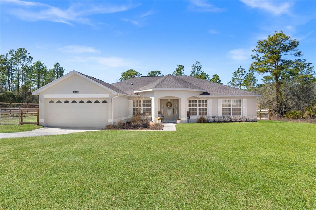 15335 Fleetwood Road Weeki Wachee, FL 34614 - Photo 1 of 40 a front view of a house with a yard and garage