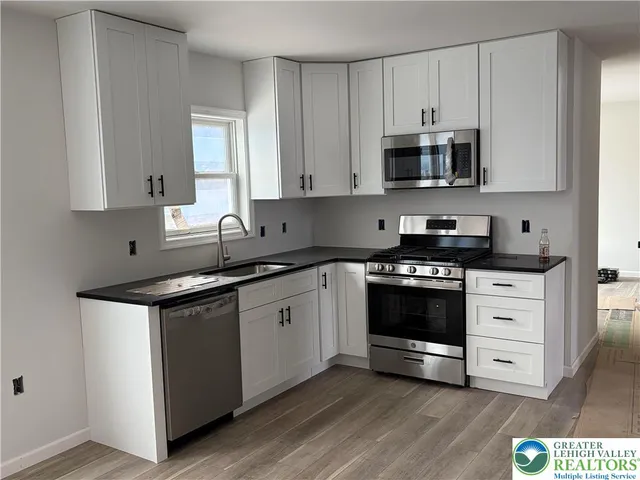 a kitchen with stainless steel appliances granite countertop a sink and a stove