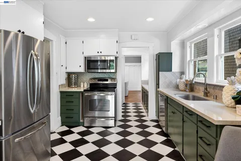 a kitchen with stainless steel appliances a refrigerator sink and microwave