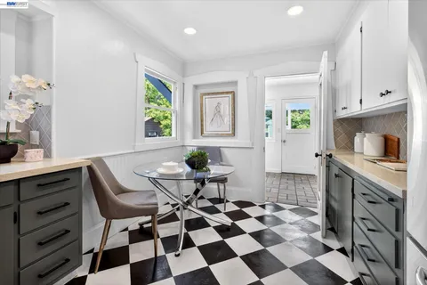 a kitchen with a checkered floor and white cabinets