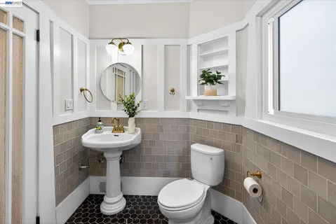 a bathroom with a toilet sink and mirror