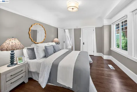 a bed room with a bed mirror and a window